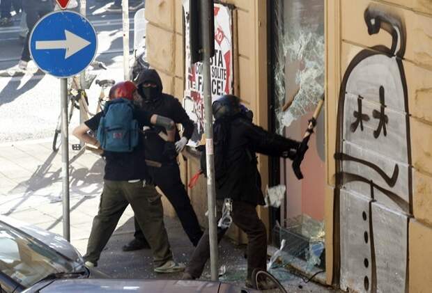 Demonstrators attempt to break through the entrance of a bank branch during a demonstration of the 'Indignant' group against banking and finance in Rome