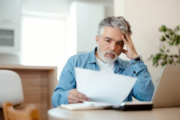 A person holding a document at a table.