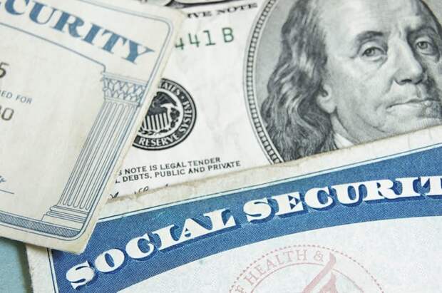 Social Security cards on top of a hundred-dollar bill.