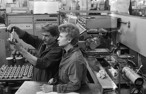 На фото: члены комсомольско-молодежной бригады Юрий Никитухин (слева) и рационализатор Александр Калетин на рабочем месте в цеху. 1984 год.