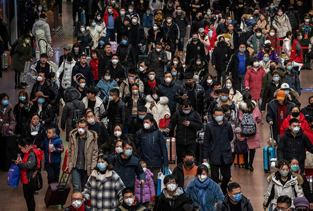 Пассажиры на железнодорожной станции в Пекине, путешествующие во время каникул в честь китайского Нового года