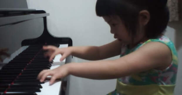 3-летняя девочка садится за пианино. Когда она начинает играть, мама тут же бежит за камерой