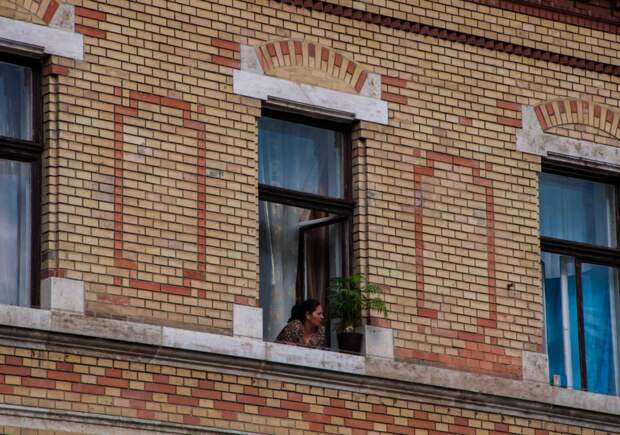 Женщина выглядывает из окна в Будапеште
