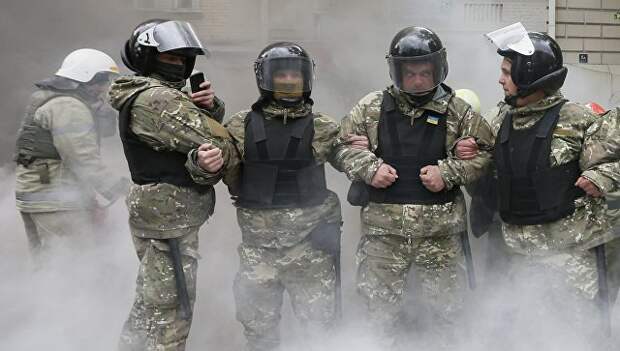 Сотрудники ОМОНа стоят в дыму. Группа людей пыталась предотвратить марш Бессмертного полка в Киева