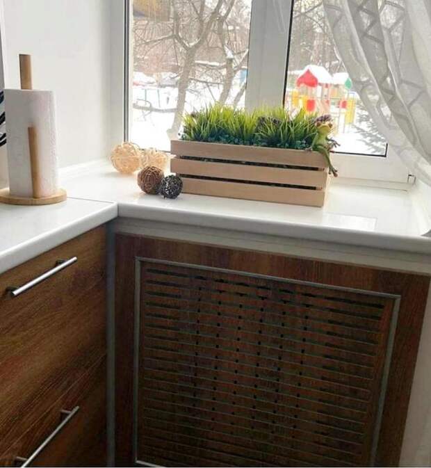 Радиатор спрятали за панелью такого же цвета, что и тумбы в рабочей зоне кухни. | Фото: lemurov.net.