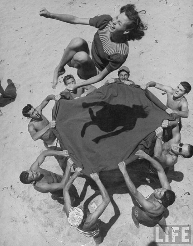 28. Парни подбрасывают свою подругу Норму Бейкер в воздух на пляже, 1948 г. архивные фотографии, лучшие фото, ретрофото, черно-белые снимки