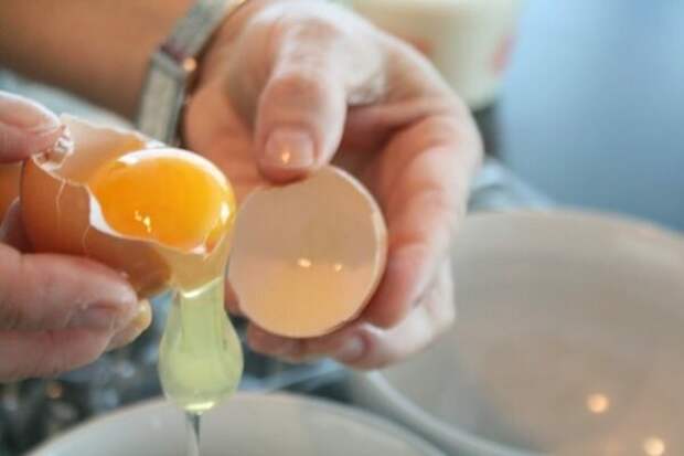 Яйца нужно предварительно отварить и остудить, лук почистить. Куриные желтки отделить от белков, натереть белки на тёрке и разделить на две части. На дно тарелки поместить часть белков.