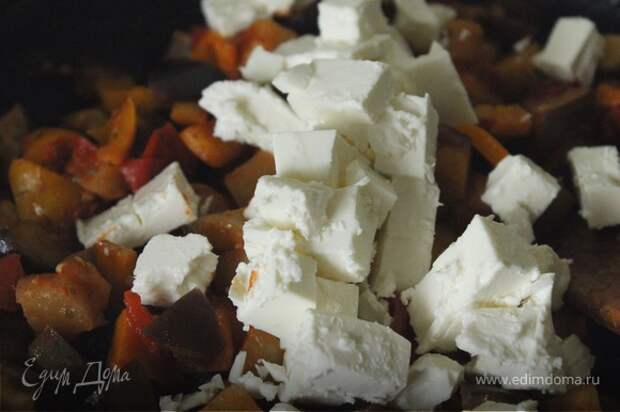 Сыр фета нарезать кубиками, добавить к овощам и перемешать.