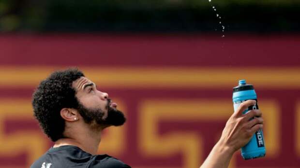 caleb williams spraying water in the air