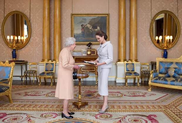 LONDON, ENGLAND - OCTOBER 10: Actress Angelina Jolie is presented with the Insignia of an Honorary Dame Grand Cross of the Most Distinguished Order of St Michael and St George by Queen Elizabeth II in the 1844 Room on October 10, 2014 at Buckingham Palace, London. Jolie is receiving an honorary damehood (DCMG) for services to UK foreign policy and the campaign to end war zone sexual violence. (Photo by Anthony Devlin - WPA Pool/Getty Images)