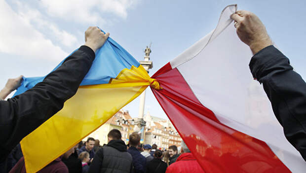 Люди держат связанные флаги Польши и Украины в Варшаве Люди держат связанные флаги Польши и Украины в Варшаве