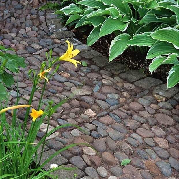 Дорожка, мощенная грубым камнем, хорошо смотрится в саду в стиле кантри