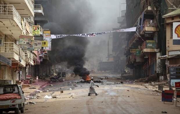 A man walks across an abandoned street during demonstrations in Kampala