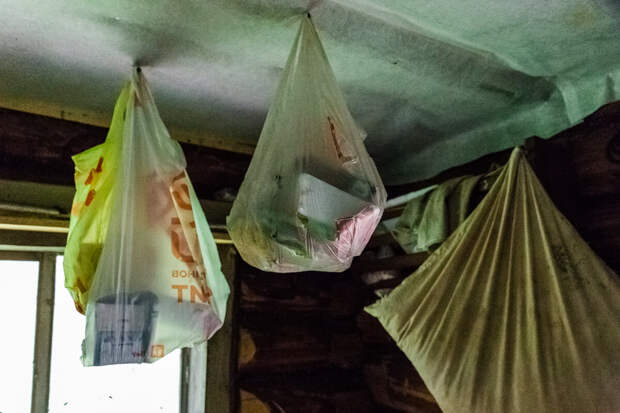 Под потолком развешены пакеты с продуктовыми запасами