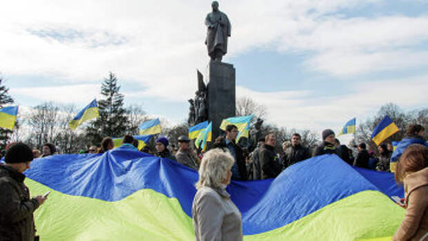 Участники демонстрации держат флаг Украины у памятника Тарасу Шевченко в Харькове. Архивное фото