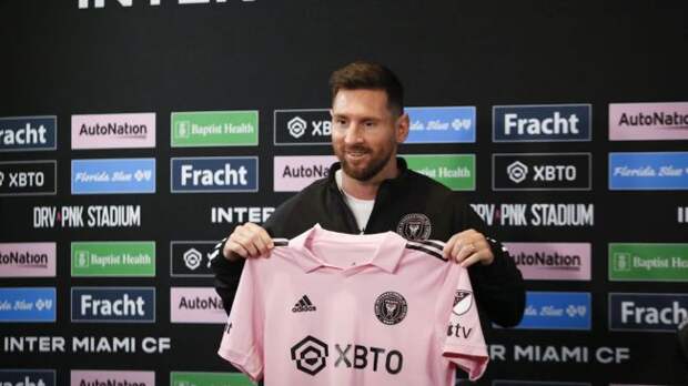 lionel messi holding an inter miami shirt