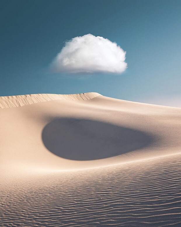 Белое облако проносится по небу над пустыней.