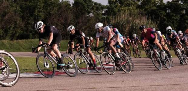 A fast-moving group of cyclists drafts one-another.