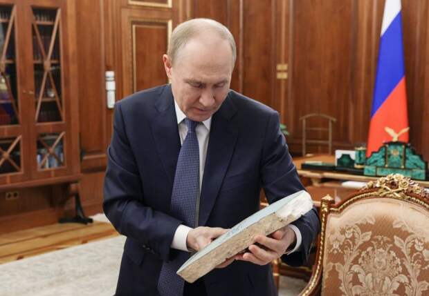 Президент РФ Владимир Путин рассматривает подарок от Вячеслава Гладкова — картину белгородской художницы, выполненную на осколке крышки корпуса ракеты ПВО С-400