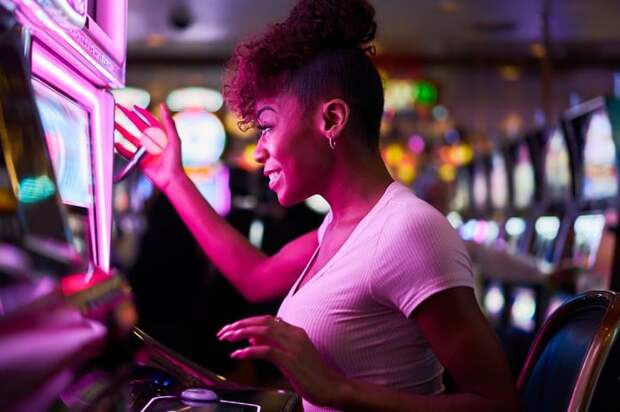 Person smiling while using slot machine in a casino