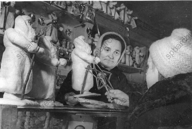 1942. Продавщица отдела игрушек одного из магазинов Ленпромторга К.И. Цыганенко показывает юной покупательнице елочные украшения 1942. Продавщица отдела игрушек одного из магазинов Ленпромторга К.И. Цыганенко показывает юной покупательнице елочные украшения