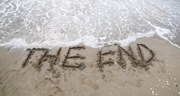 The End carved in sand on the beach