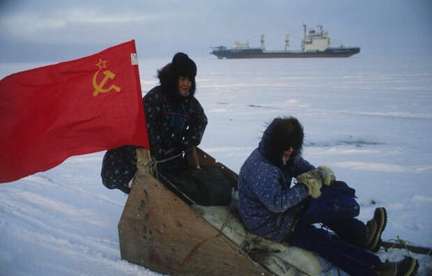 Жители Барроу закрепили советский флаг на санях; на заднем плане "Владимир Арсенев". / Getty Images