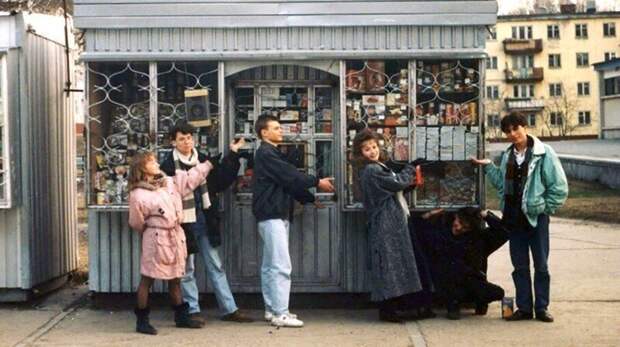 Молодые люди возле ларька с широким ассортиментом товаров, Россия, 1990 е годы