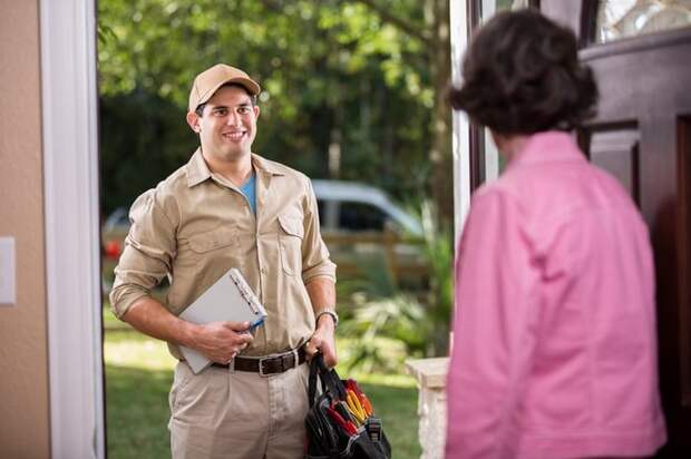 Homeowner opening the door for repairman.