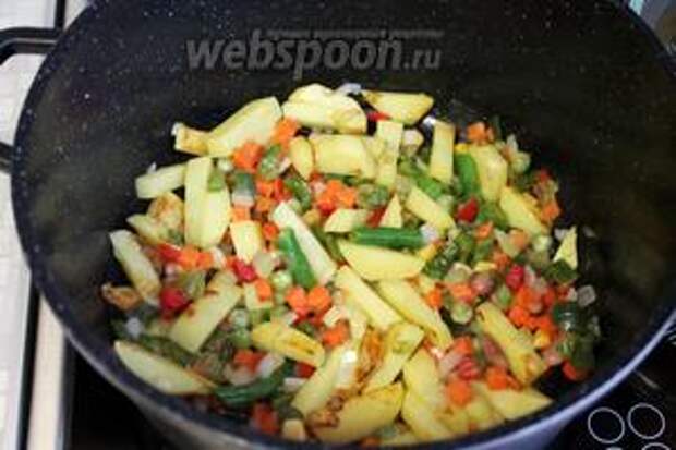 Добавить овощную смесь, всё перемешать, чуть пожарить и добавить воды (0,5 стакана), накрыть крышкой, убавить огонь и тушить до готовности овощей.