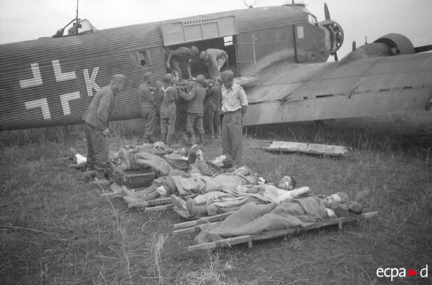 На немецком аэродроме раненых грузят в транспортный самолет Юнкерс Ju-52 На немецком аэродроме раненых грузят в транспортный самолет Юнкерс Ju-52