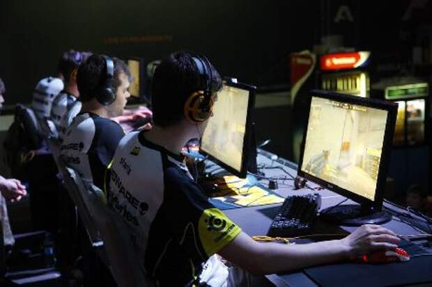 киберспортсмены за компьютерами на турнире крупным планом