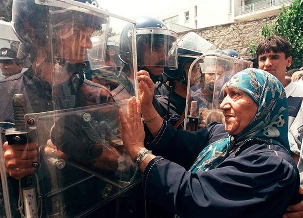 Пожилая женщина пытается сдерживать полицейских на митинге за культуру и демократию, Алжир, 2011 демонстрации, женщины, кадры, общество, протест, сильные женщины, сильные фотографии, фото