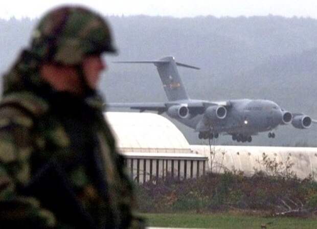 An American soldier stands guard on the tarmac of the U.S. Ramstein Airbase in Germany October 8, 2001, as a C-17 Globemaster III airplane lands on its way back from Afghanistan, dropping "Humanitarian Daily Ration" packs during last nights operation Enduring Freedom. The U.S. Defense Department said they dropped some 37,500 of the HDR packages last night over Afghanistan, containing Beans with Tomato Sauce, Beans and Tomato Vinaigrette, Biscuit, Fruit Pastry, Fruit Bar, Short Bread, Peanut Butter, Strawberry Jam, instructions, and utensils package including salt, pepper, napkin and a match. REUTERS/Vincent Kessler JOH/WS - RP2DRIOYXMAA