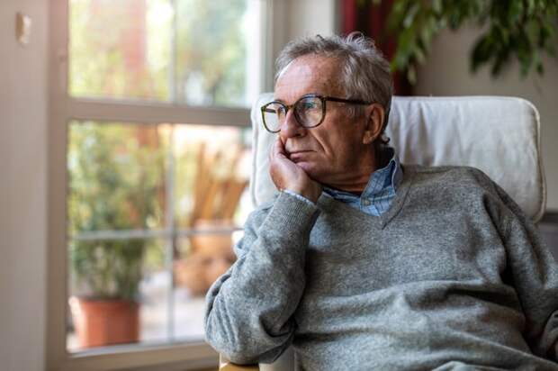 Person sitting in chair and looking outside.