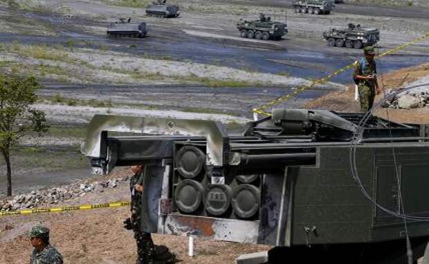На фото: HIMARS (высокомобильная усовершенствованная ракетная система) американского производства на фоне бронетранспортеров