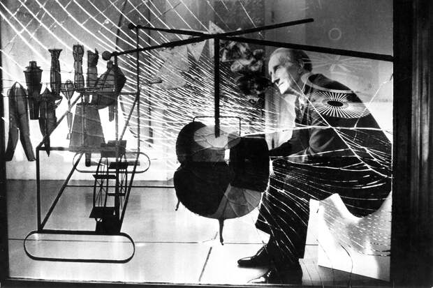 Марсель Дюшан рассматривает через стекло свою работу «Холостяки раздевают невесту догола»