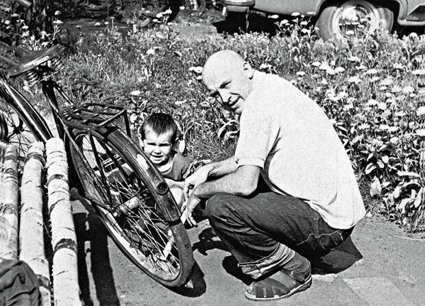 1084 Смоктуновский с дочерью Машей накачивают на даче шину велосипеда, 1968 г. В то время Иннокентий Михайлович готовился к съемкам в фильме «Чайковский» и, чтобы парик лучше сидел, побрился наголо.jpg