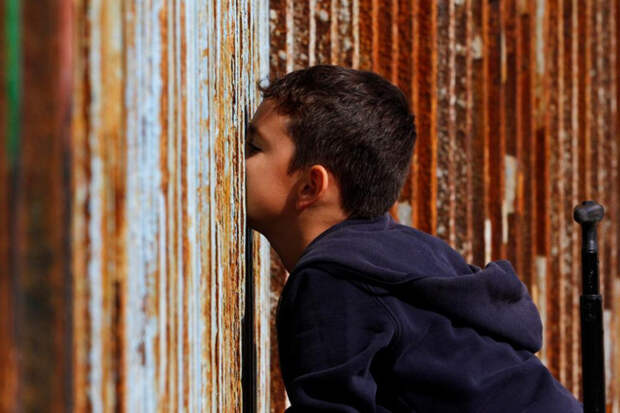 Мальчик из Мексики разговаривает с родственниками по ту сторону границы граница, мексика, сша