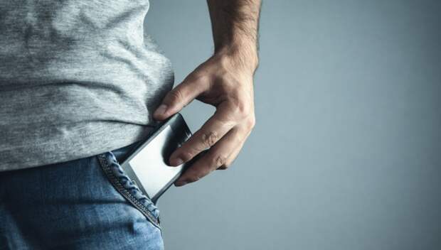 man putting phone in pocket