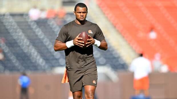 deshaun watson standing and holding a football