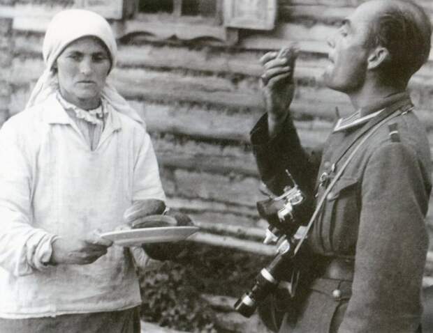 Офицер пробует огурцы в белорусской деревне.