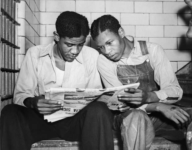 Чарли Веймс (слева) и Кларенс Норрис, обвиняемые по делу Скоттсборо, читают о себе на тюремной скамье в Декатуре. 16 июля 1937 г. / AP