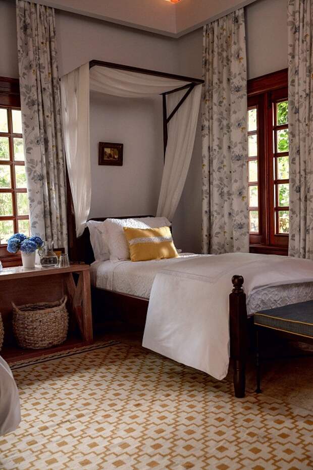 Уютная спальня, оформленная в испанском стиле с выбеленными стенами и темными деревянными окнами. | Фото: Тьяго Молинос (Tiago Molinos).