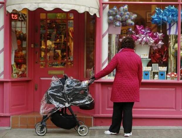 A woman stops to look in the window of a shop in London March 25, 2014. REUTERS/Luke MacGregor