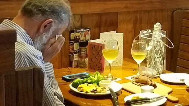 A man seen sitting at a restaurant dining with his wife's ashes.