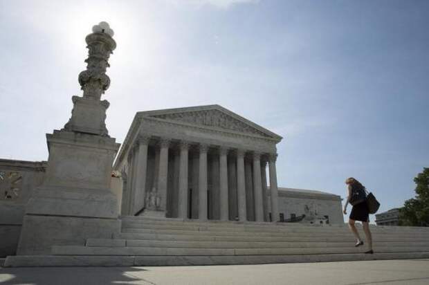 A woman walks to the Supreme Court in Washington June 19, 2014.  REUTERS/Joshua Roberts