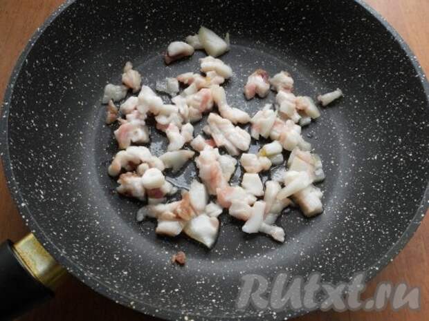 Сало нарезать мелкими кусочками и поместить на сковороду, добавить одну столовую ложку растительного масла. Обжарить сало до тех пор, пока из него не вытопится достаточно жира. 