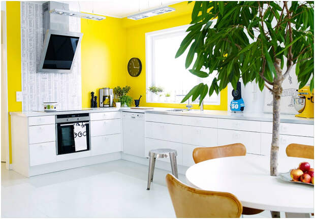Желтые стены удачно разбавляются белой мебелью и зелёными растениями