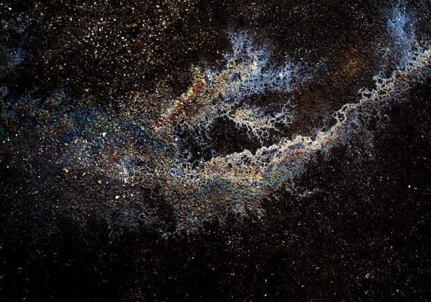 Иллюзорные галактики и созвездия из бензина и масла на асфальте